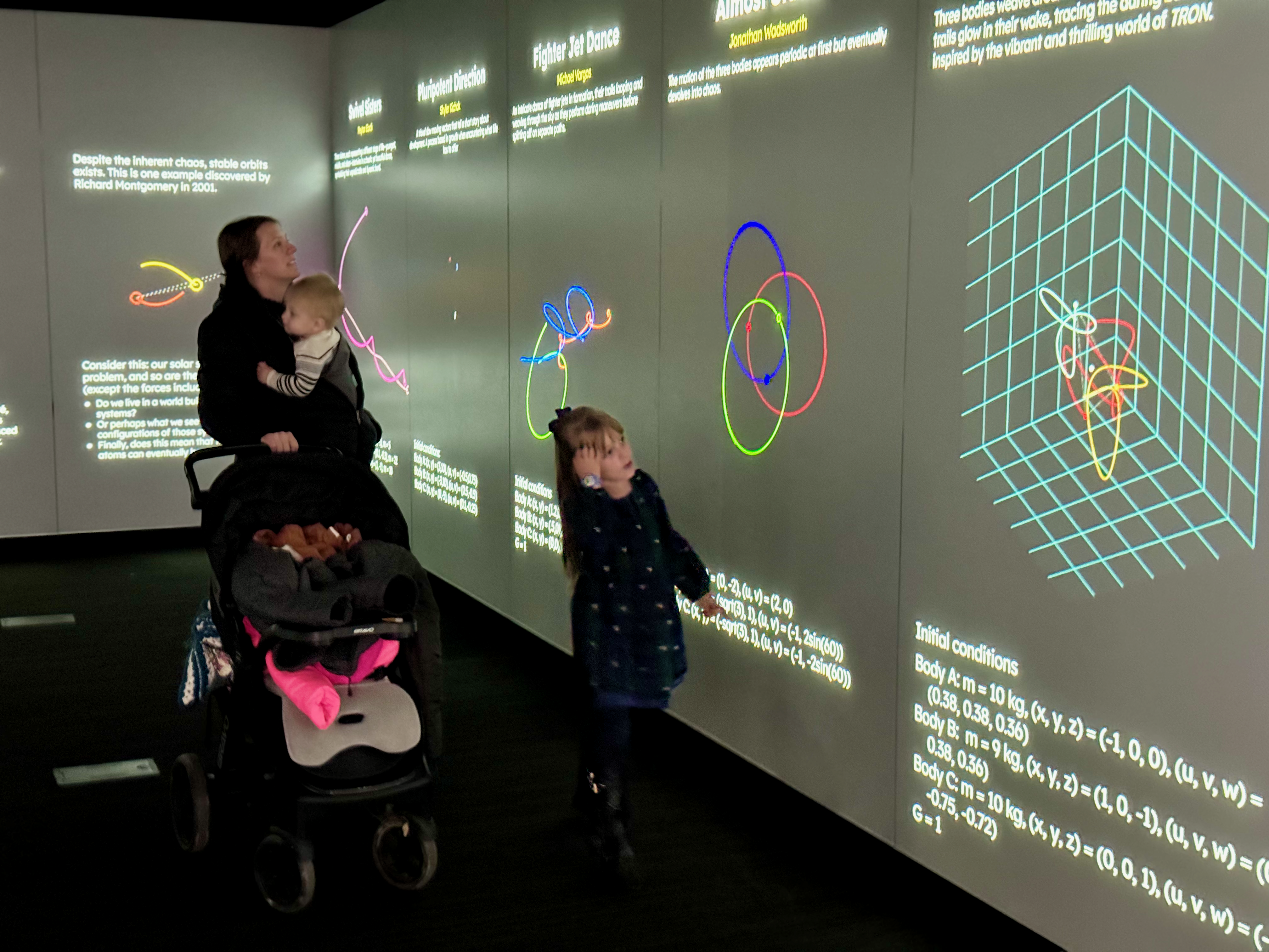 The image shows a family exploring the math exhibition