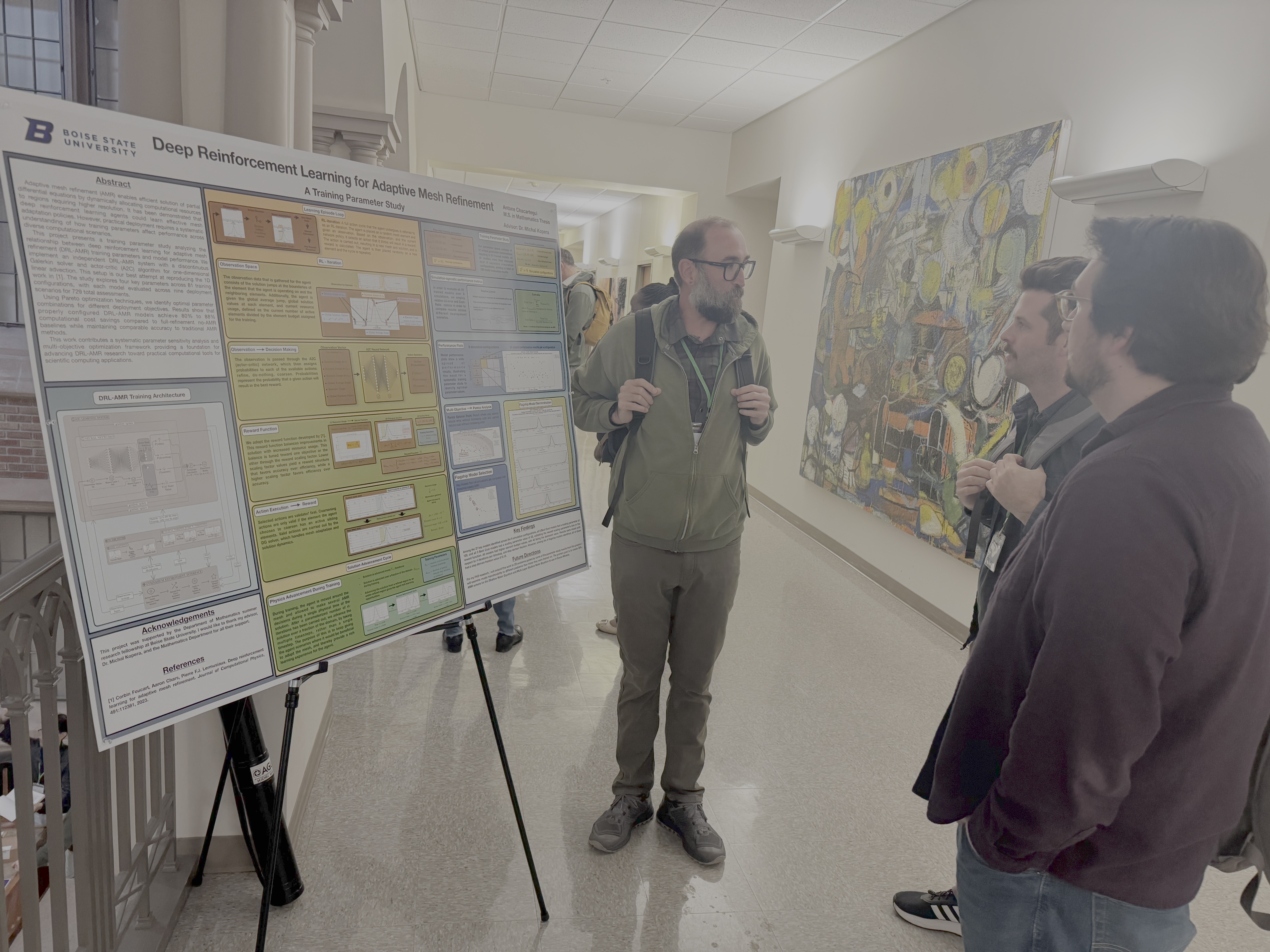 The image shows students discussing a research poster. Antone Chacartegui is presenting his work on deep reinforcement learning applied to adaptive mesh refinement